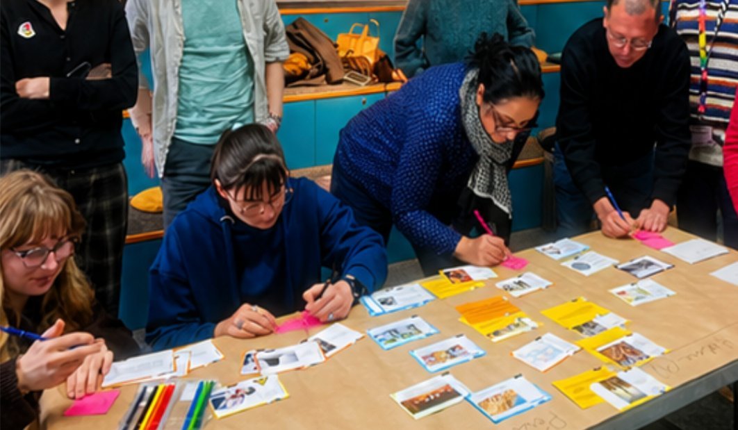 Participants d'un atelier de la Fresque contre l'antisémitisme positionnant des cartes sur une table